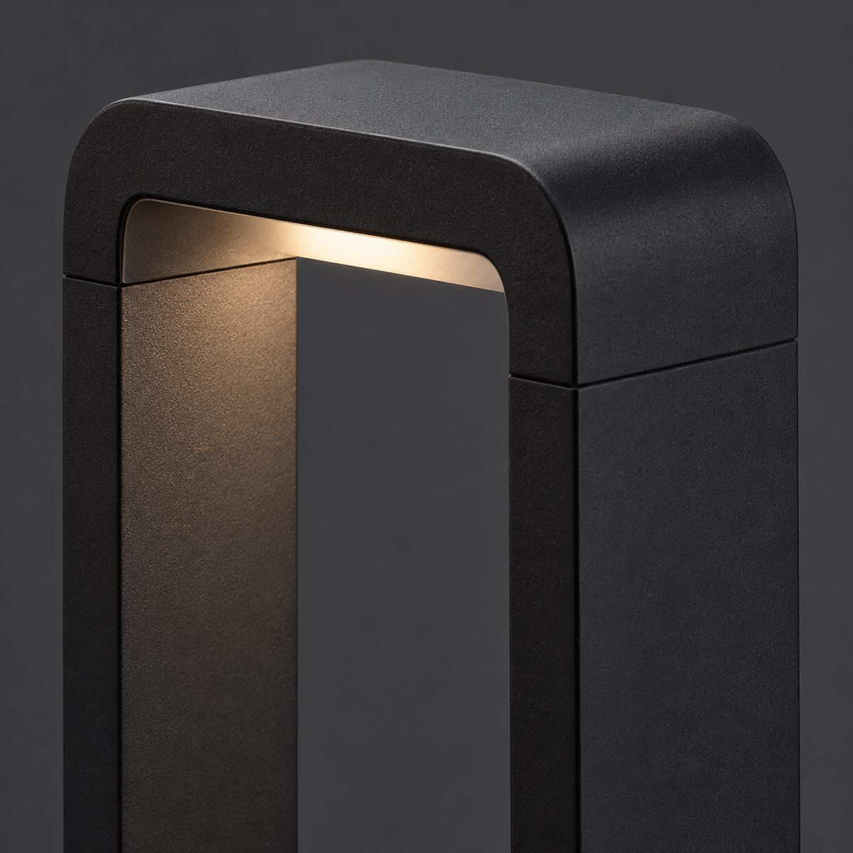 Close-up of the rounded upper frame and light opening of a black bollard