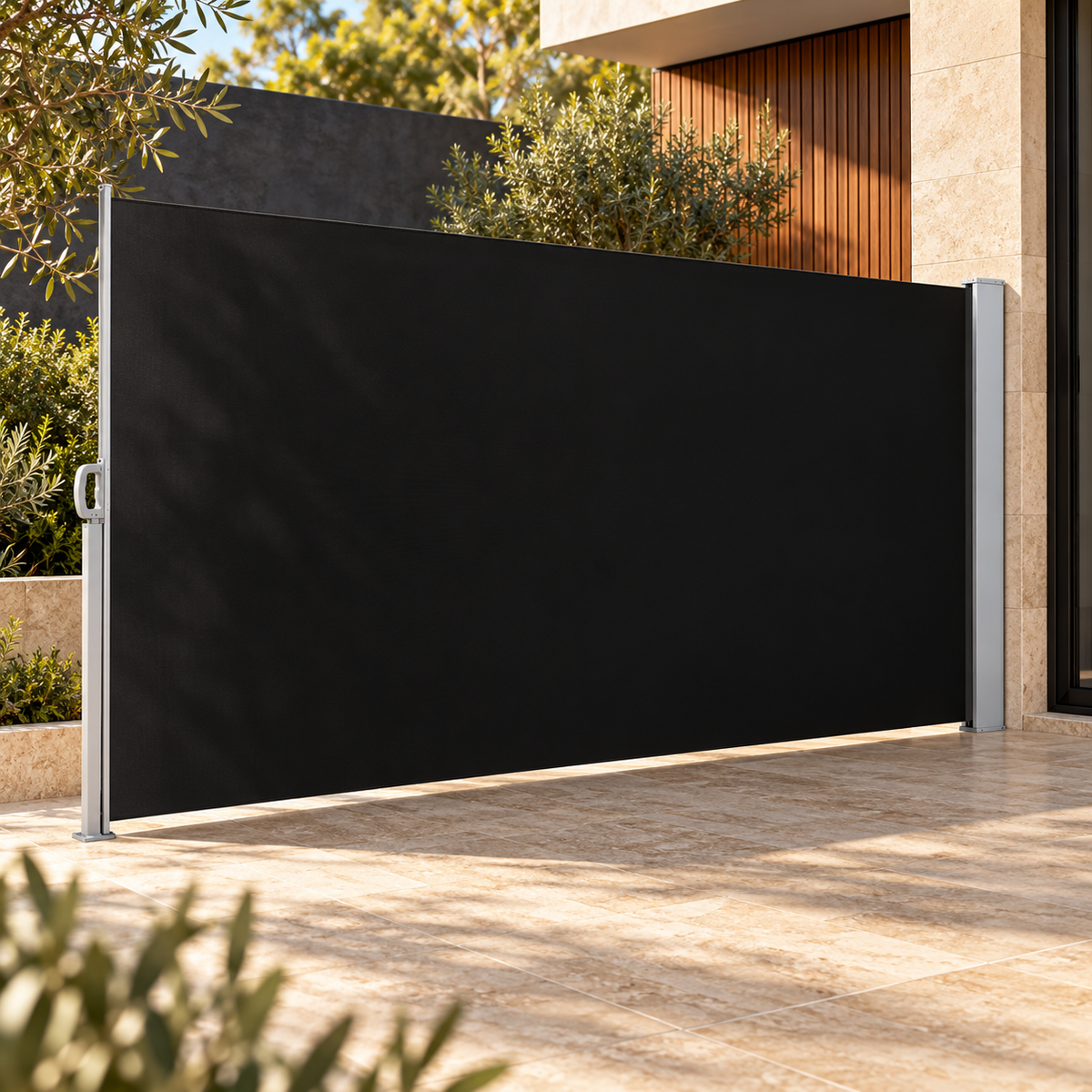 Black retractable side awning with silver-grey hardware in a stone courtyard